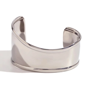 Detailed close-up of a wide open silver-tone cuff bracelet with polished mirror finish