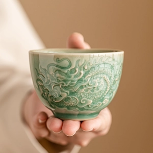 Ceramic green tea cup with embossed dragon motif in traditional Chinese style