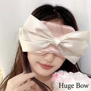 Pink satin sleep mask featuring a large oversized cream bow and comfortable elastic headband