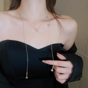Gros plan détaillé d'un long collier doré avec des perles de zircone sur un mannequin