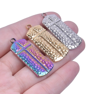 Detailed view of hammered rectangle cross pendants in rainbow, gold, and silver finishes