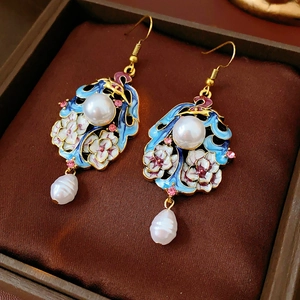 Macro shot of vintage enamel flower earrings with pearls and pink rhinestones in jewelry box