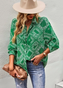 Detail of green paisley long sleeve shirt styled with denim jeans and fashion accessories