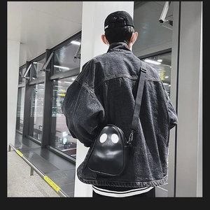 Rear view of a model wearing the black ghost PU leather crossbody bag in a city setting