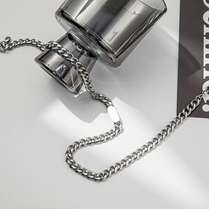Detailed macro view of silver Cuban link necklace with rectangular polished metal plate