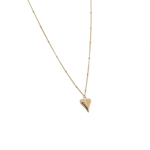 Minimalist gold heart pendant necklace with elegant beaded chain on white background