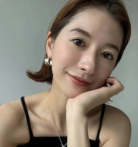 Close-up of minimalist silver C-shaped earrings and necklace set on a model