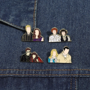 Detail view of four Twilight-inspired enamel pins on denim fabric showing movie characters