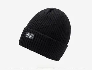 Close-up of black ribbed knit beanie featuring a stitched FUMY logo patch detail