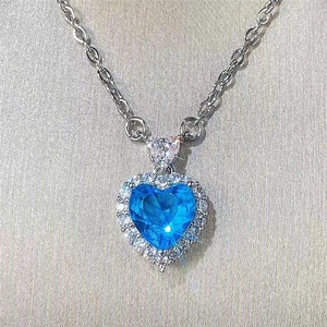 Close-up of heart-shaped blue topaz pendant necklace with clear diamond halo
