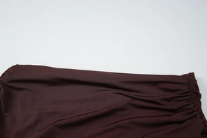 Gros plan détaillé de la robe en maille marron foncé montrant les textures plissées