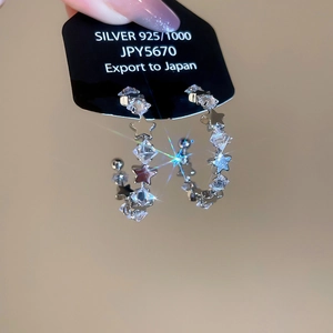 Macro shot of S925 silver C-shape earrings with sparkling zircon stars and gift card