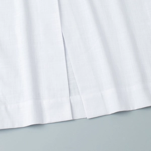 Detailed close-up of the side slit and linen texture on white sleeveless dress skirt