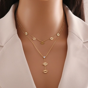 Double layered gold necklace featuring a stylized eye pendant with an inlaid heart
