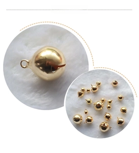 Macro shot of gold plated round bell accessories with integrated top loop for DIY crafts
