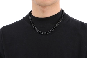 Close-up of polished black stainless steel Cuban link chain necklace on male model