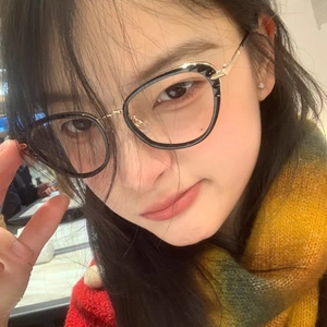 Retro cat-eye black frame glasses with gold metal temples worn by a model in a close-up view