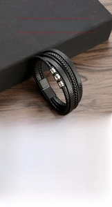 Close-up of men's leather braided bracelet featuring stainless steel beads and magnet clasp