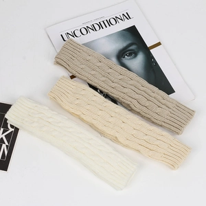 Detailed cable knit texture on beige, taupe, and white arm warmers for autumn fashion