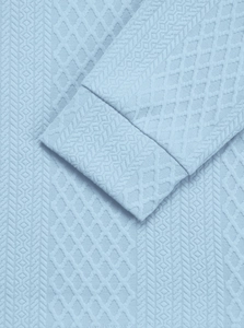 Macro detail of light blue knitted fabric showing rhombus texture and ribbed cuff finishing