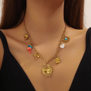Golden stainless steel necklace featuring celestial charms and pearl accents on model