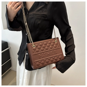 Detail of a brown embossed PU leather bag featuring a gold chain strap and fashion text