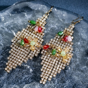 Detailed macro view of bohemian gold flower earrings with crystals and colorful beads