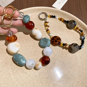 Detailed macro view of retro acrylic resin beaded phone chains with marble and amber textures