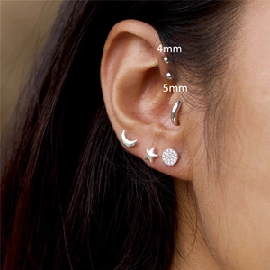 Detailed view of silver S925 sterling silver ball stud earrings set on ear cartilage