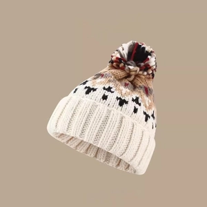 Detailed close-up of thick knit winter hat showing weaving texture and colorful pompom