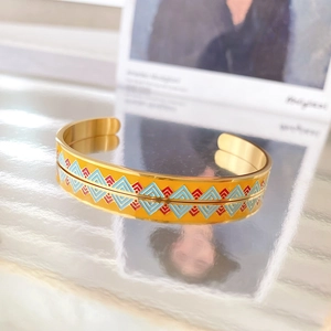 Golden titanium steel open bangle featuring colorful enamel geometric triangle patterns