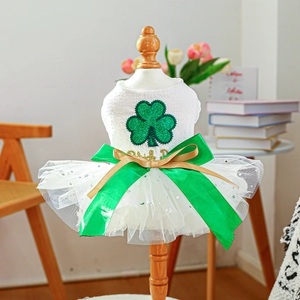 Detail of pet holiday tutu dress featuring green glitter shamrocks and silk bow on a mannequin