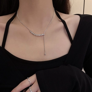 Detail of silver butterfly necklace with crystal tassels and wave texture rings