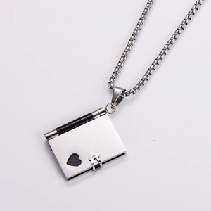 Detail of silver book-shaped pendant necklace with heart cutout and metal chain link