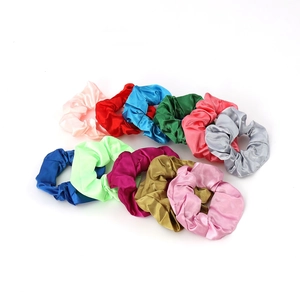 Set of 12 colorful satin silk hair scrunchies stacked on a clean white background