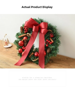 Detailed view of Christmas wreath with red bow, pine cones and berries on wood table