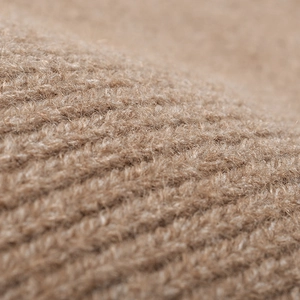 Close-up of warm camel knitted wool beanie hat with premium ribbed texture and soft fabric