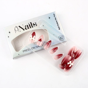 Detail of red and pink gradient press on nails with 3D bows and heart patterns