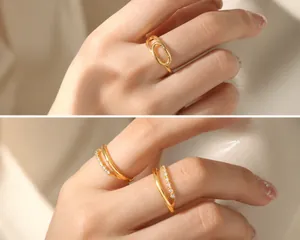 Detail of gold-plated geometric rings with wave patterns and zircon pavé settings