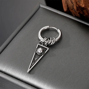 Macro view of vintage silver steel hoop earring with geometric triangular dagger pendant