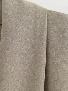 Macro shot of khaki woven fabric texture and stitching on the minimalist kimono set