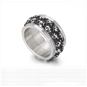 Macro shot of 12mm wide punk style spinning ring with embossed skull heads in steel