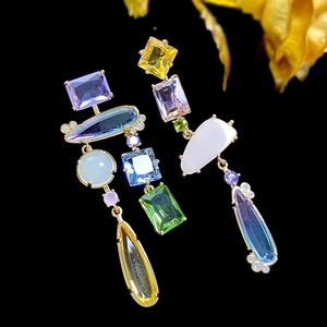 Detailed view of asymmetric candy-colored gemstone earrings with gold-tone settings