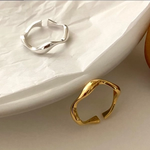 Detail of silver and gold irregular wave rings showing S925 engraving on the inner band