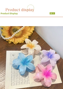 Detail of four vibrant gradient frangipani flower hair claws in colorful resin materials