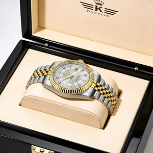 Detailed macro view of two-tone gold and silver watch dial with calendar and Roman numerals
