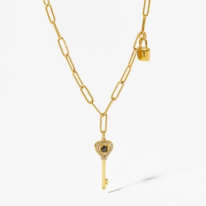 Golden necklace with heart-shaped key pendant and small lock charm on white background