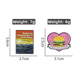 Detailed view of enamel badges with sunset landscape and avocado burger designs