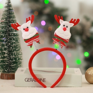 Detail of Christmas headband featuring red reindeer horns with spring bouncers and bows
