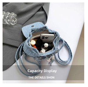 Internal storage view of mini denim backpack showing space for smartphone and lipstick